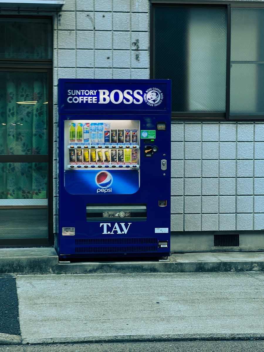 A blue vending machine sitting on the side of a road
